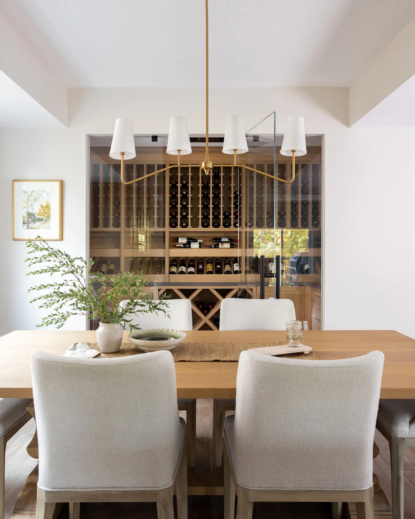 Dining table in front of a floor-to-ceiling glass wine wall