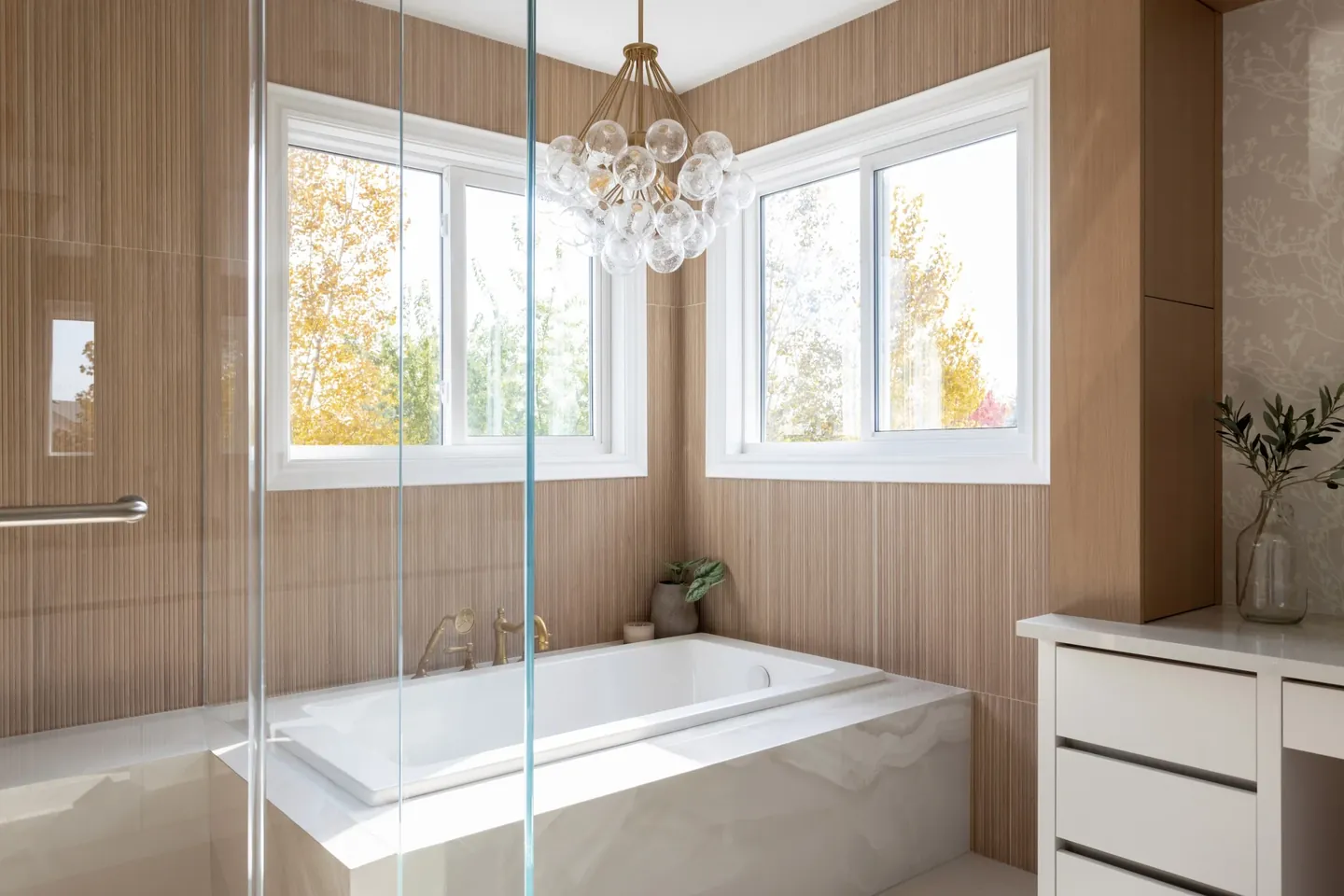 Freestanding soaker tub between two windows in a renovated ensuite