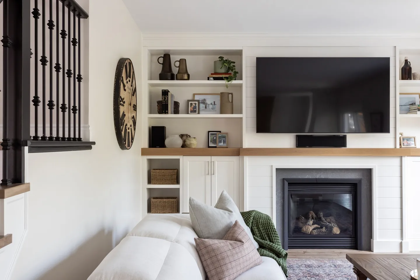 Family room with a linear fireplace, built-in shelving and a white sectional